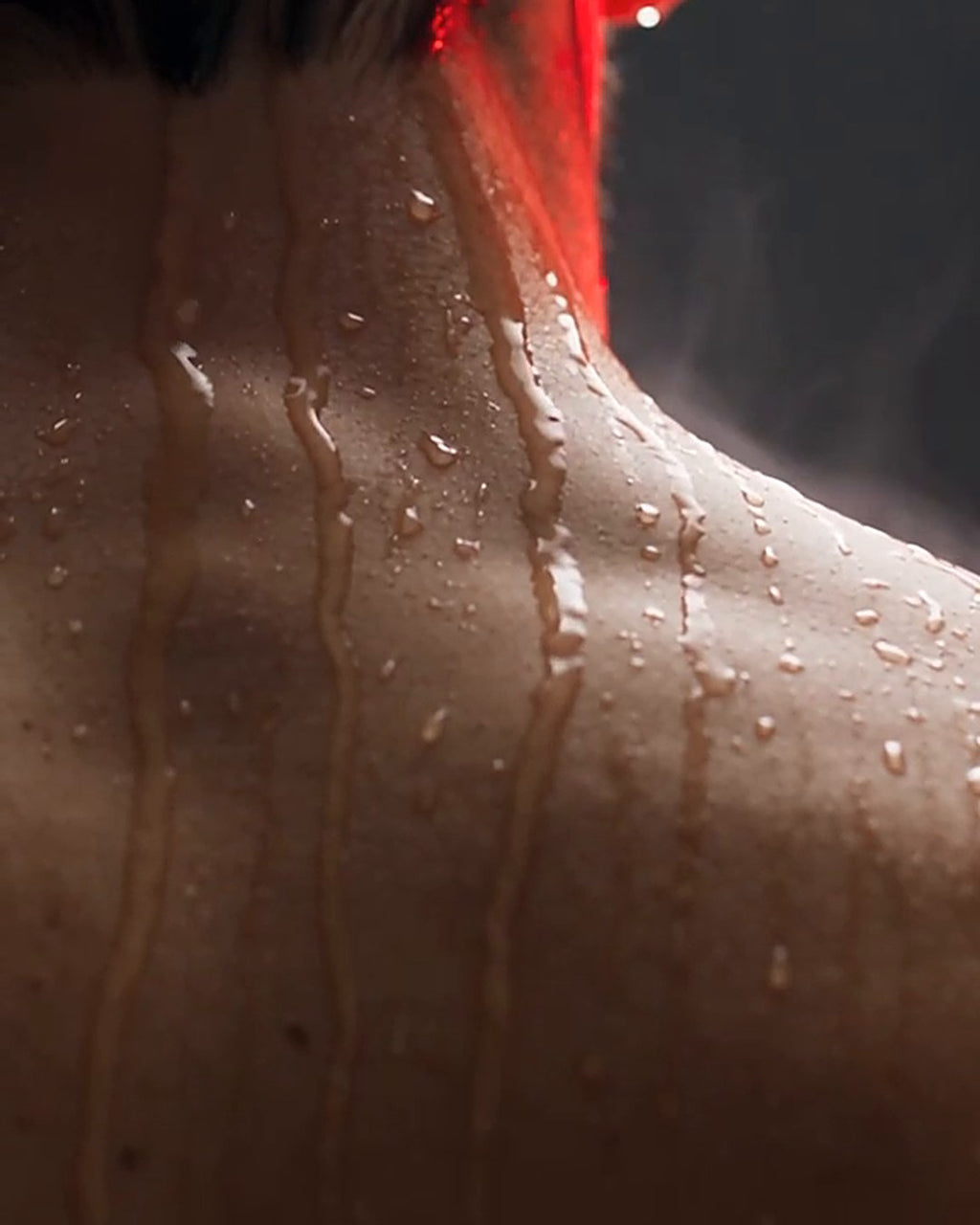 Water droplets running down a man's neck and shoulders in the shower